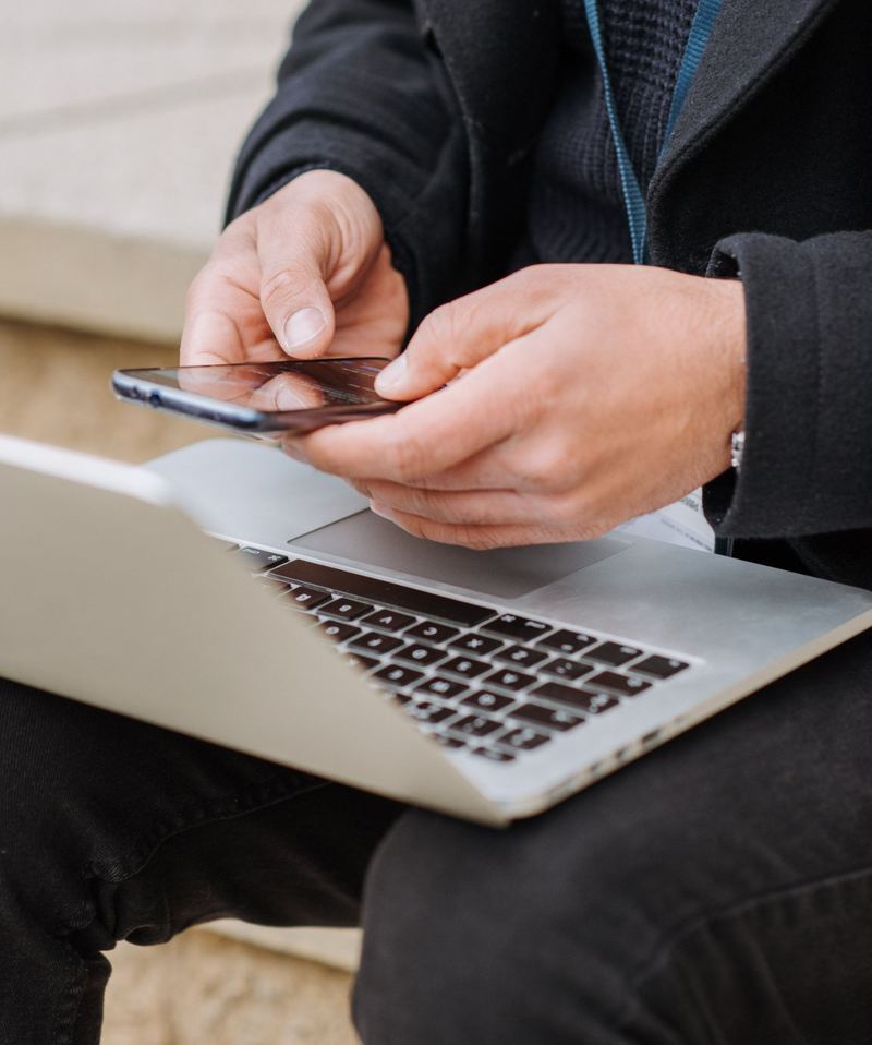 A professional working on a phone and laptop