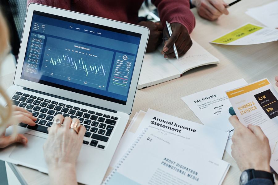 A team reviewing financial reports and charts on a laptop